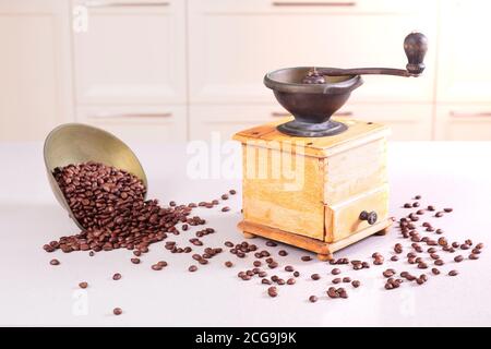 Macinacaffè vecchio e un recipiente con i chicchi fuoriuscito Foto Stock