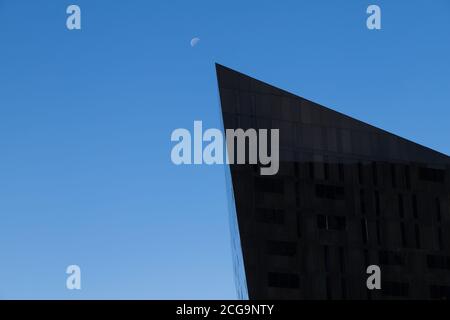 Il bordo appuntito di un edificio sul complesso di Mann Island punta verso la luna a Liverpool nel settembre 2020. Foto Stock