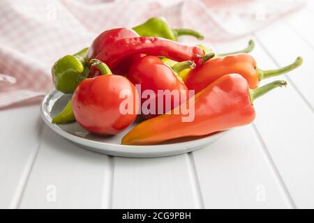 Vari tipi di peperoni vegetali su tavola bianca. Foto Stock
