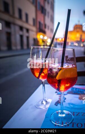 Due bicchieri di Campari Soda e limone su tavola in legno rustico