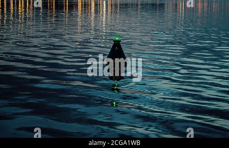 Vista delle acque blu e scure del fiume e della boa, che ondeggia sulle onde. Boa ondeggia in twater come indicatore di sicurezza e di navigazione al porto o porto Foto Stock