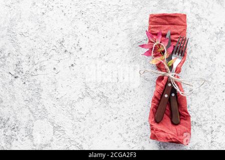 Luogo di autunno di ringraziamento con posate e disposizione delle foglie di caduta su sfondo grigio. Concetto di cena per le feste di ringraziamento. Bockup per il mare Foto Stock