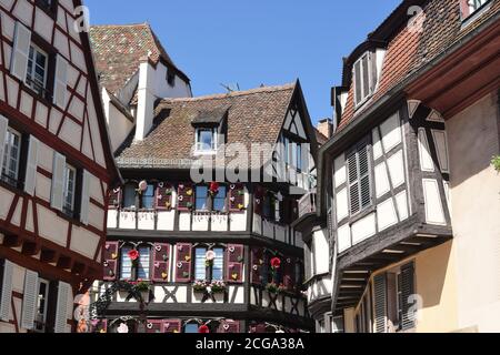 Edifici medievali e del primo Rinascimento a graticcio con finestre drappeggiati di fiori a Colmar, una città nella regione del Grand Est della Francia. Foto Stock