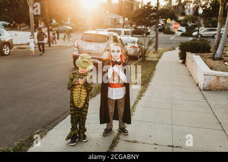 Giovani fratelli vestiti in costumi Trick-or-treating su Halloween Foto Stock