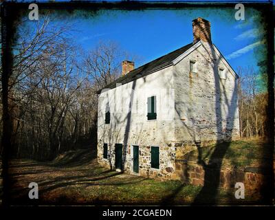 Una casa di pietra abbandonata si trova sterile nei boschi lungo il canale C&o alzaia e il fiume Potomac nella campagna del Maryland. Foto Stock