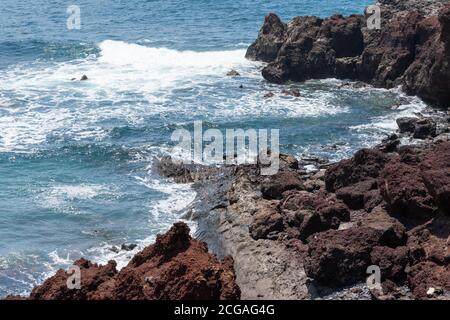 Bellissimo paesaggio dove il mare e la costa di pietra vulcanica di Lanzarote, spagna Foto Stock