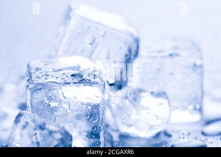 Tre cubetti di ghiaccio fondente su sfondo luminoso. Foto Stock