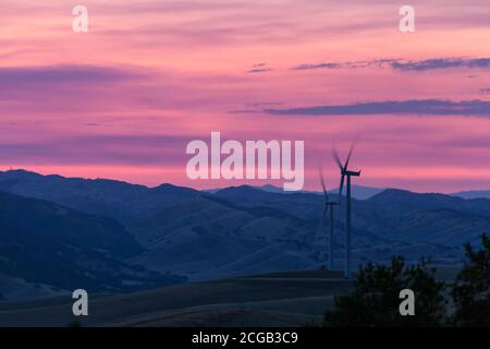 Mulini a vento che generano elettricità sulla catena del Diablo al tramonto vicino al Brushy Peak dell'East Bay Regional Park a Livermore, California. Foto Stock