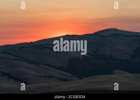 Fuma dai vicini selvaggi a colori il tramonto sulla catena Diablo dal Brushy Peak dell'East Bay Regional Park a Livermore, California. Foto Stock