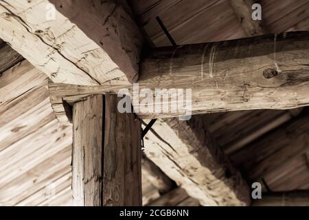 Vecchio tetto in legno costruzione interna. Tronchi e tavole ruvidi Foto Stock