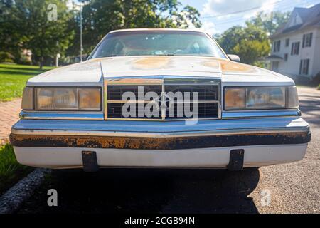 Chestertown, MD, USA 08/30/2020: Vista frontale di una vecchia auto bianca arrugginita Dodge Dynasty LE parcheggiata all'esterno della strada. Ha arrugginito e scheggiato pai Foto Stock