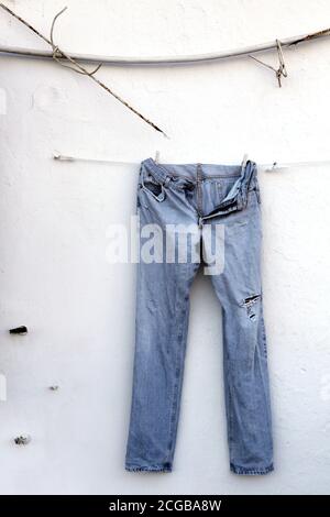 Gallipoli - vecchi jeans che si asciugano su pareti sbiadite Foto Stock