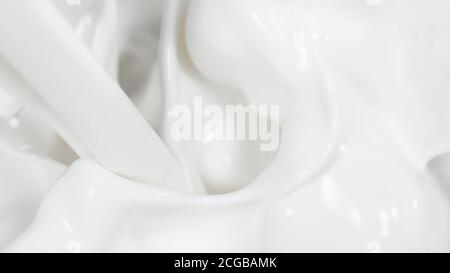 Macro shot di crema antigoccia in dettaglio. Primo piano di latte fresco o panna. Foto Stock
