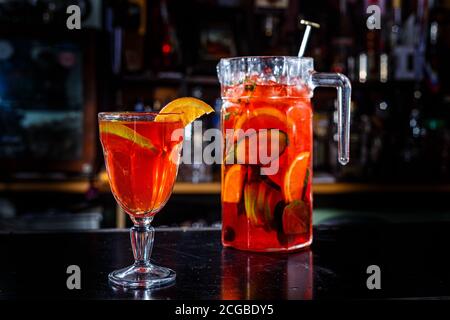 Limonata d'arancia con arancio e cetriolo si trova sul bancone di una barra scura. Foto Stock