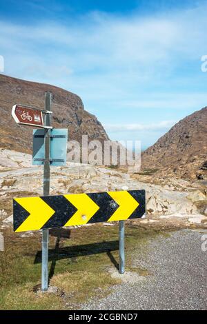 Dirigiti verso il Gap come punto più alto, cartelli stradali e vista panoramica sul Gap of Dunloe vicino a Killarney, County Kerry, Irlanda Foto Stock