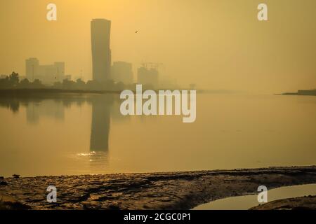 Sunrise Sky vista sfondo dietro la torre della porta capitale di Abu Dhabi, grattacieli nella capitale degli Emirati Arabi Uniti Foto Stock