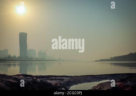 Sunrise Sky vista sfondo dietro la torre della porta capitale di Abu Dhabi, grattacieli nella capitale degli Emirati Arabi Uniti Foto Stock