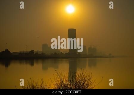 Sunrise Sky vista sfondo dietro la torre della porta capitale di Abu Dhabi, grattacieli nella capitale degli Emirati Arabi Uniti Foto Stock