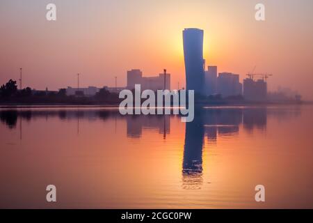 Sunrise Sky vista sfondo dietro la torre della porta capitale di Abu Dhabi, grattacieli nella capitale degli Emirati Arabi Uniti Foto Stock