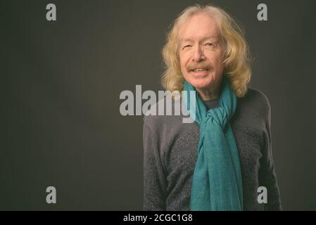 Senior uomo con i baffi contro uno sfondo grigio Foto Stock