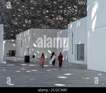 Un'immagine interna del Louvre Abu Dhabi che include i visitatori, il suo tetto ad alta tecnologia con luce a filtrazione e le pareti bianche della facciata dei suoi vari spazi espositivi. Aperto a novembre 2017. Foto Stock