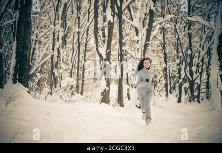 giovane donna attiva in tuta sportiva nella foresta invernale Foto Stock
