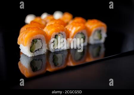 Set di sushi al salmone. Sushi roll Philadelphia con pesce rosso, salmone, caviale rosso. Arrotolare con avocado morbido e formaggio cremoso sotto uno strato di caviale massago Foto Stock