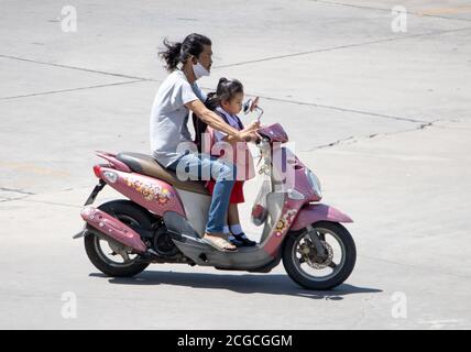 SAMUT PRAKAN, THAILANDIA, 23 2020 LUGLIO, un uomo con una bambina corre una moto. Foto Stock