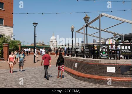 I turisti camminano lungo la South Bank del Tamigi a Londra, Inghilterra. Foto Stock