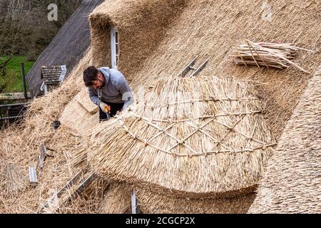 operai che stacciano il tetto di una vecchia casa Foto Stock