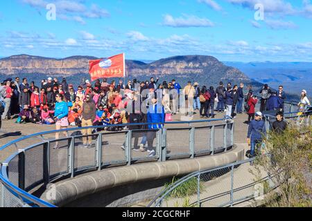 I turisti, tra cui un gruppo cinese con bandiera, si trovano al punto panoramico Echo Point nelle Blue Mountains, Australia Foto Stock