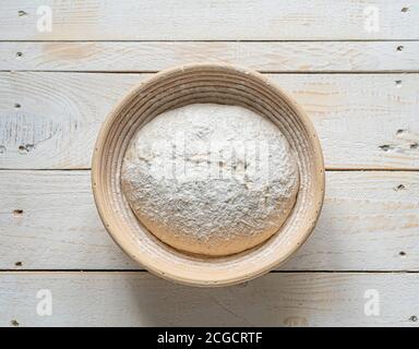 Impasto di pane in banneton di vimini con cesto di prova su legno sfondo Foto Stock