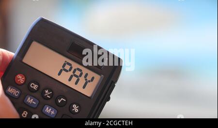 Paga parole sul display della calcolatrice. Concetto aziendale e fiscale Foto Stock