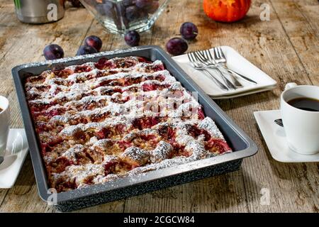 torta crumble di prugne appena sfornata su un tavolo Foto Stock