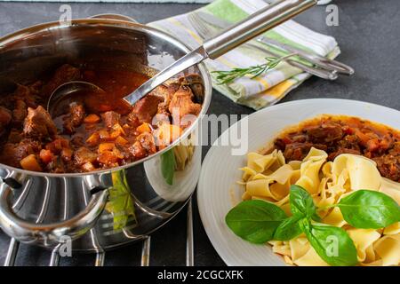 stufato di maiale brasato fresco con pasta servito in un pentola Foto Stock