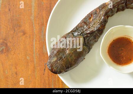immersione di pesce gatto alla griglia con salsa piccante su piatto Foto Stock