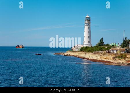 Paesaggio blu del mare con faro bianco sulla terna Foto Stock