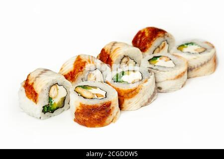 Rotolo di sushi con anguilla e insalata di chuka su un piatto bianco, sushi giapponese classico. Cucina tradizionale giapponese con maki. Deliziosi pezzi di sushi. per il menu del ristorante. copyspace. Foto Stock