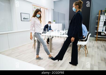 Piedi toccare saluto per evitare e arrestare Covid o influenza Foto Stock