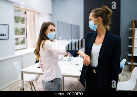 I dipendenti che fanno gomito a massa per evitare influenza e Stop Covid Diffusione Foto Stock