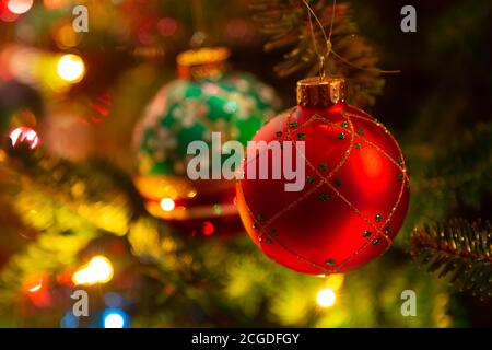 Ornamenti natalizi appesi in un albero di Natale illuminato in abete balsamo. Foto Stock