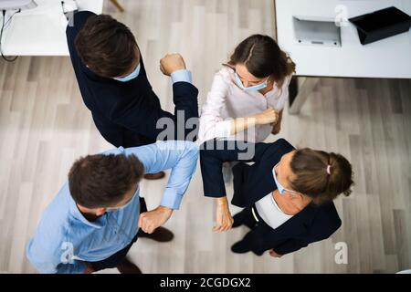 I dipendenti che fanno gomito a massa per evitare influenza e Stop Covid Diffusione Foto Stock