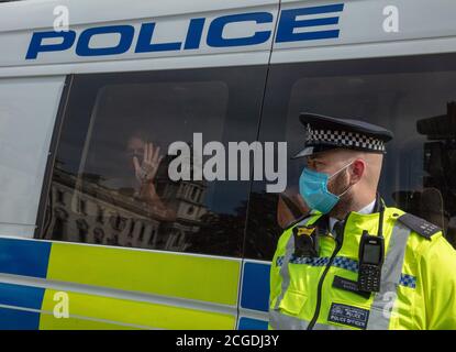 Londra, Regno Unito. 10 settembre 2020. Una donna di Extinction Rebellion, il gruppo di azione ambientale, visto in un furgone di polizia, dopo essere stato arrestato di fronte alle Camere del Parlamento, preme il palmo della sua mano contro la finestra mostrando un messaggio. Credit: Joe Kuis / Alamy News Foto Stock