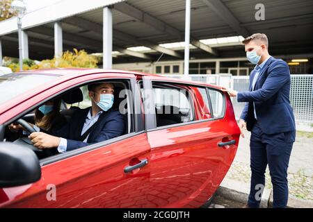 Condivisione di auto e carpooling di persone con maschere facciali Foto Stock