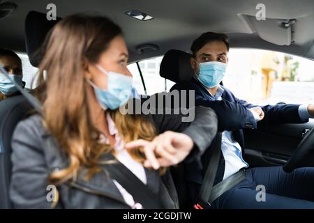 Condivisione di auto e carpooling di persone con maschere facciali Foto Stock