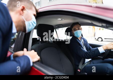 Condivisione di auto e carpooling di persone con maschere facciali Foto Stock