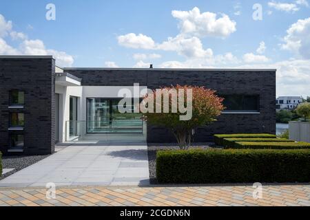 un bungalow moderno con siepe verde in un giardino facile cura senza piante da parassiti, vista da terra pubblica Foto Stock