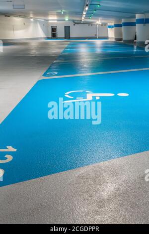 Cartello parcheggio per disabili in garage pubblico in blu. Fuoco selettivo sul segno. Foto Stock