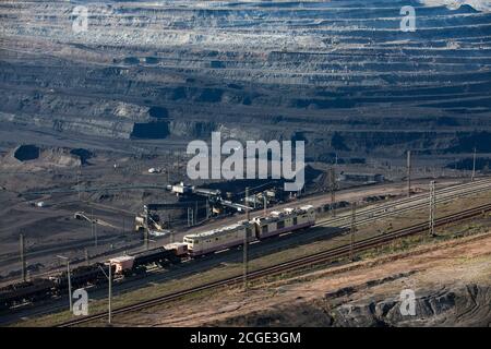 Estrazione a cielo aperto di carbone in cava 'Bogatyr', Ekibastuz, Kazakhstan. Macchina da cava, trasportatore a nastro e caricatore e treno su rotaie. Foto Stock