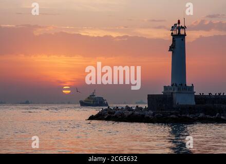 Faro di Haydarpasa breakwater , barche e mare vicino al tramonto, İstanbul, Turchia Foto Stock
